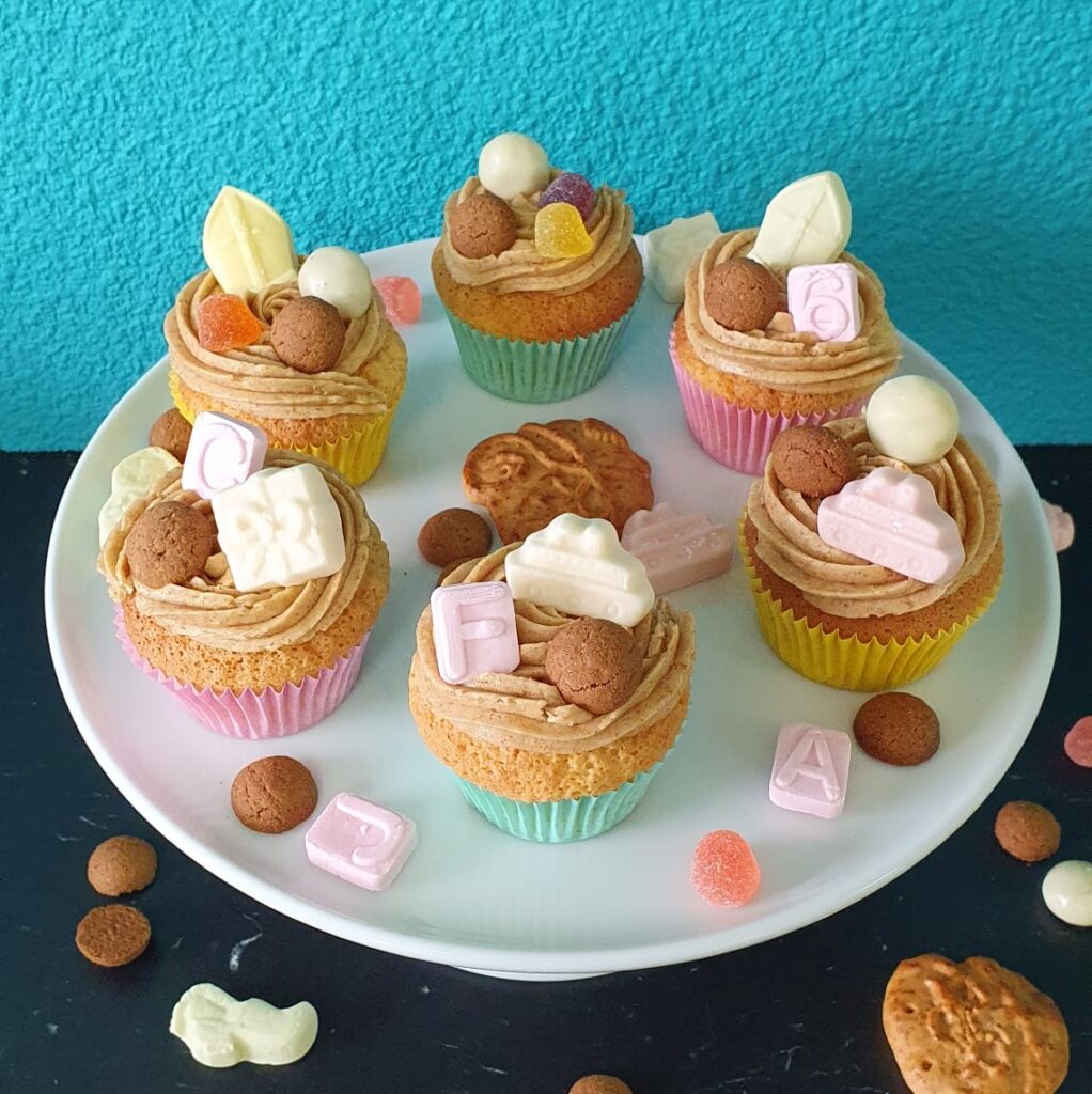 Vanille cupcakes met een toef van kruidnootjes botercrème. Versierd met allerlei Sinterklaas lekkers.